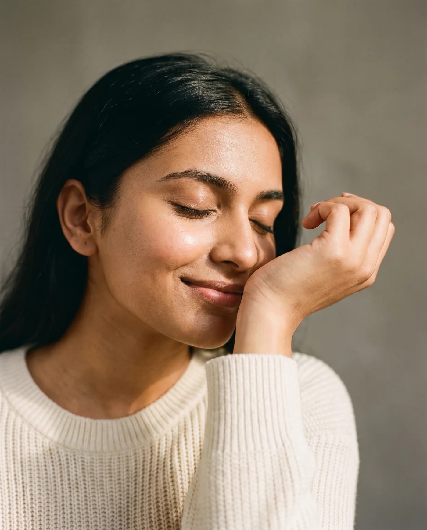 A woman smelling perfume on her wrist